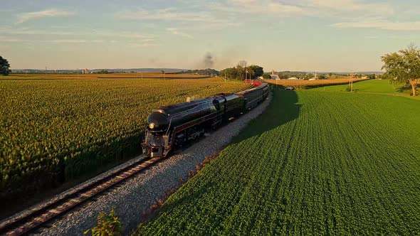 Aerial View of a Steam Engine Puffing Smoke and Steam with Passenger Coaches Traveling