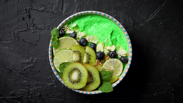 Green Smoothie or Yogurt Bowl. With Fresh Kiwi, Blueberries, Lime and Almond Flakes