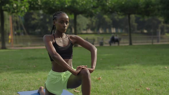 Woman Doing Flexible Exercises on Yoga Mat Outdoors