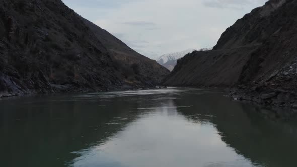 Flying a Drone Over a Beautiful River Flowing Between Two Large Mountains