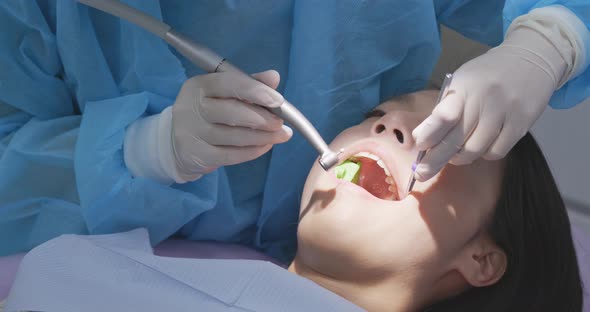 Woman undergo professional tooth whitening and ultrasound cleaning at dental clinic