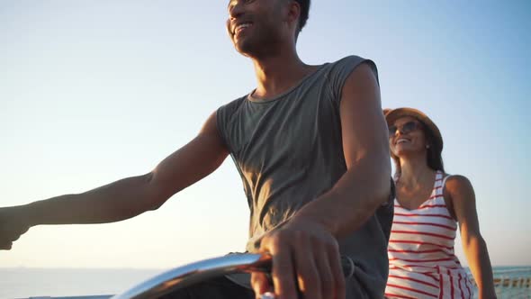 Portrait of a Mixed Race Couple Riding on Tandem Bicycle Outdoors Near the Sea Slow Motion