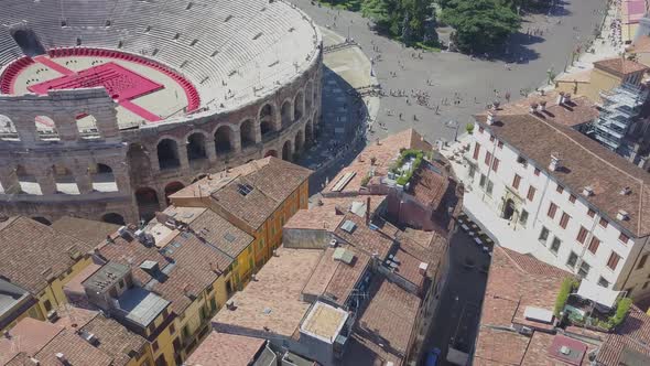 Aerial panoramic view of Arena di Verona, Italy. The drone hovers over the houses with tiled roofs