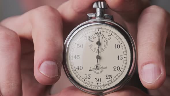 Stopwatch in Male Hand Counts Down Seconds