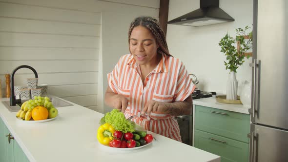 Black Charming Young Woman Eating Healthy Food with Pleasure Indoors