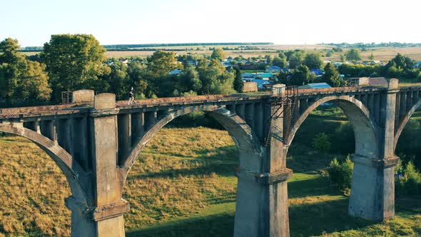 Sportsman Is Running Along an Old Massive Bridge