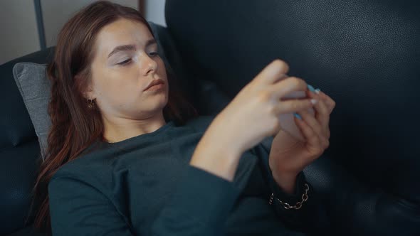 Frame of a Young Woman Relaxing Playing Video Games on the Phone