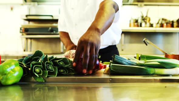 Chef cutting vegetables in commercial kitchen