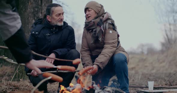 Ukrainian Refugees Roasting Sausages At Bonfire