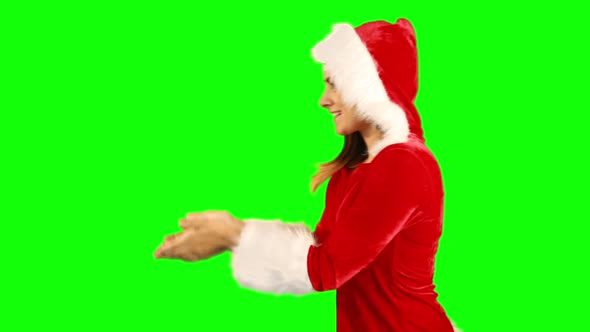 Girl in santa hat blowing over hands and looking at camera