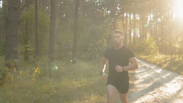 Young Athletic Man Running on Nature During Summer Sunset