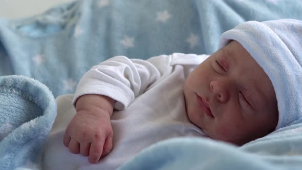 Newborn Baby Face Portrait Early Days in Macro Sleeping And Open Eyes On Blue Star Background