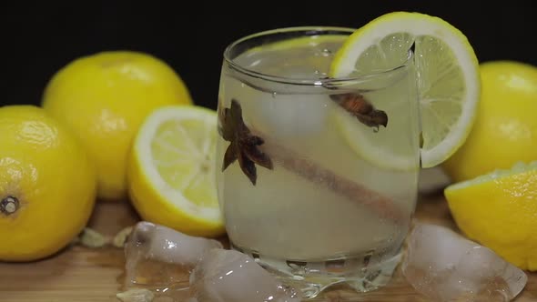 Refreshing Alcoholic Cocktail Drink on Rustic Wood Board. Adding Ice Cubes