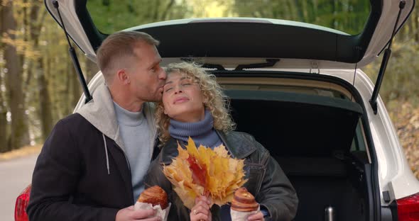 Lovely Couple Sitting in the Trunk of a White Car