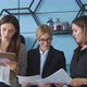Three business girls stand in the office and look at documents and a tablet, they discuss business  - VideoHive Item for Sale