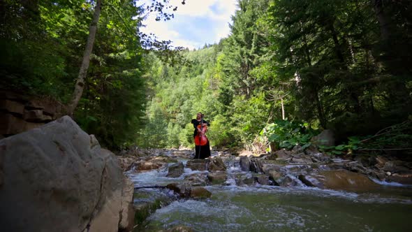 Beautiful girl with the cello in the river.