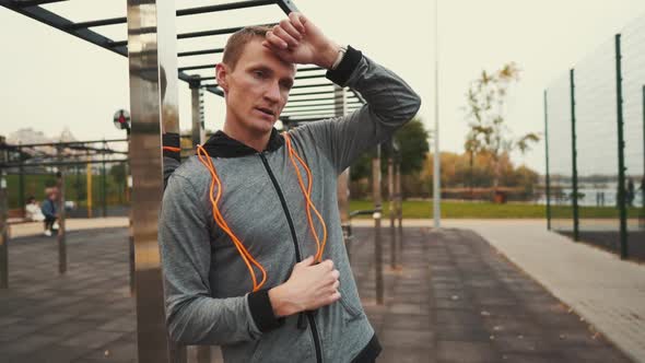 Man Checks Heart Rate on Smartwatch After Jumping Rope Workout at Street Gym