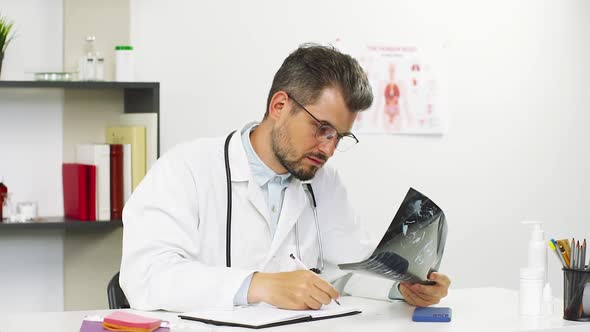 Doctor Working on X-ray of Patient in Hospital