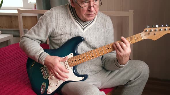 Senior Man is Playing Guitar