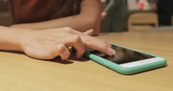 Woman working on smart phone in cafe