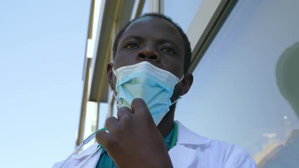 work in the hospital during covid - doctor pulls down his mask staring at camera