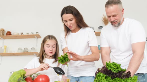 Happy Family Preparing Dinner in the Kitchen at Home