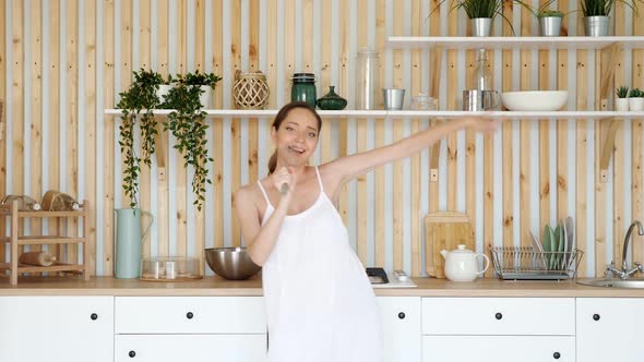 Pregnant Woman Dances and Sings with Whisk in Kitchen