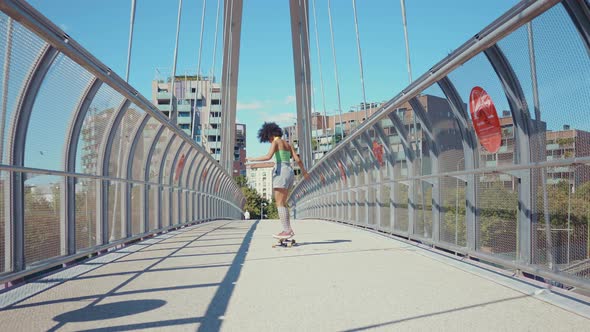 Beautiful young woman cruising around the city with her longboard.