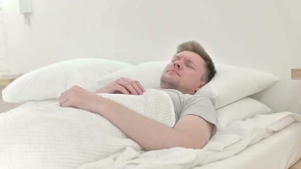 Long Shot of Man Having Back Pain While Sleeping