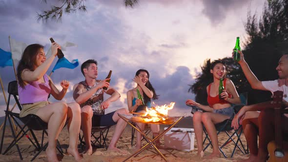 Group of Asian young man and woman having party on the beach at night.