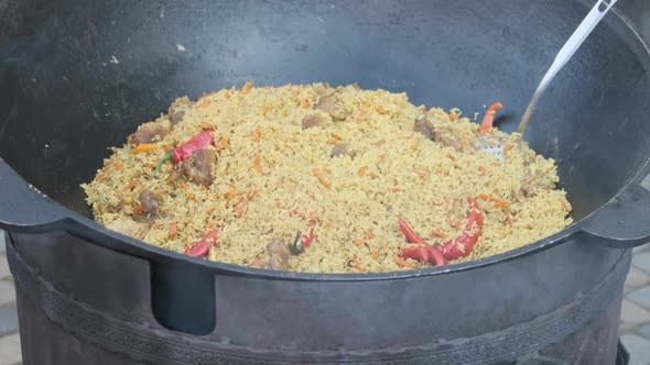 Big Vat with Cooked Pilaf or Rice Over an Open Fire. Street Food at the Party