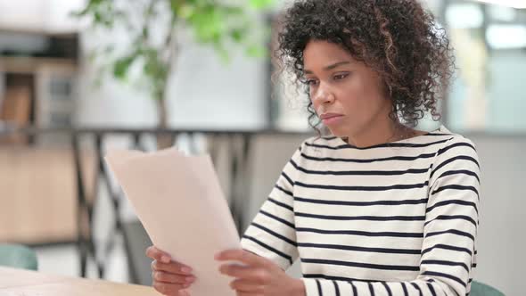 Close Up of Young African Woman Reading Documents