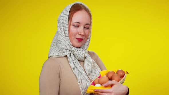 Charming Redhead Slim Woman with Green Eyes in Kerchief Posing with Poultry Eggs at Yellow