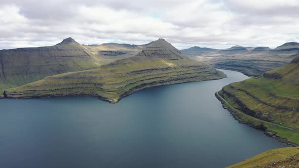 Flying Around a Hiker at the Top of a Mountain Above Funningur on Faroe Islands