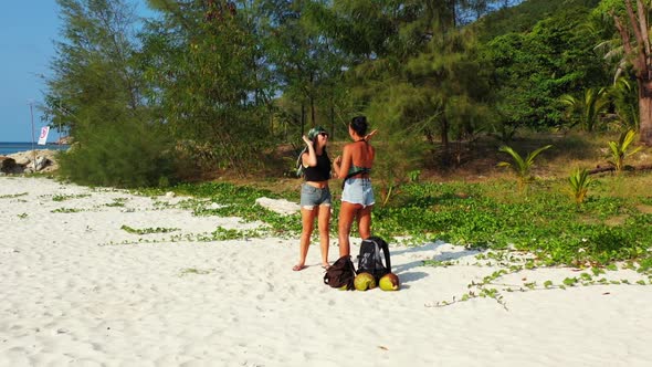 Ladies relaxing on luxury shore beach time by shallow ocean and white sand background of Thailand ne