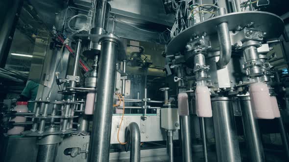 Working Machine Fills Bottles with Yogurt.