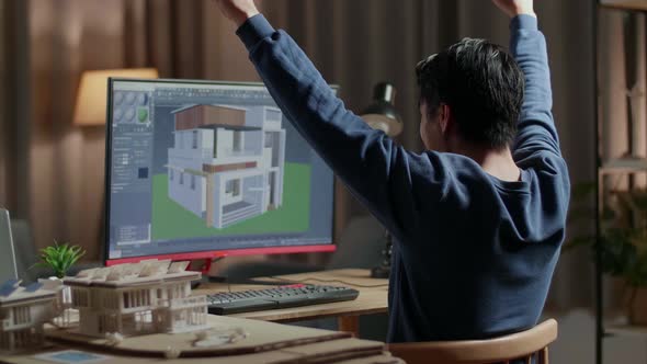 Asian Male Engineer Celebrating While Designing House On A Desktop At Home