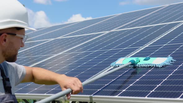 Worker Cleans Solar Panel with Water Clean at Solar Power Plant