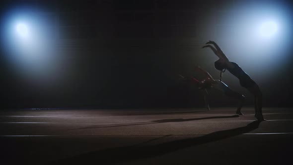 Three Sporty Girls are Doing Backflip Synchronously in Sports Hall Floor Exercise of Artistic