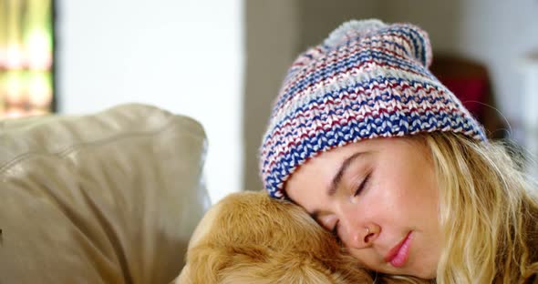 Woman relaxing with her dog on sofa at home 4k