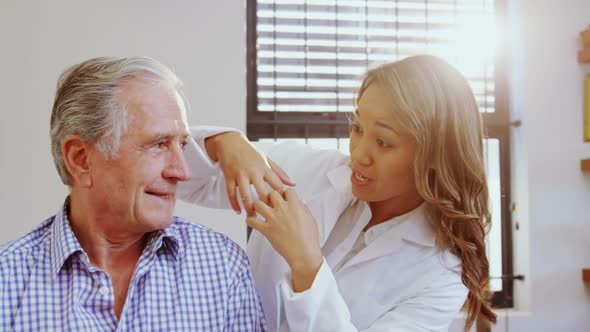 Physiotherapist assisting senior man while consulting 4k