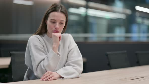 Beautiful Woman Sitting in Office and Thinking