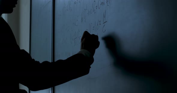 Scientist Writing Formulas On Chalkboard