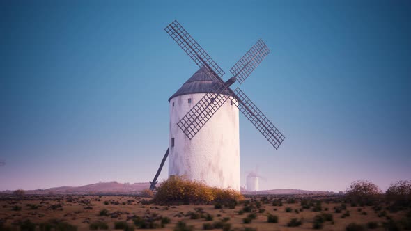 Closeup shot of a vintage Spanish windmill's wings rotating slowly at sunset. 4K