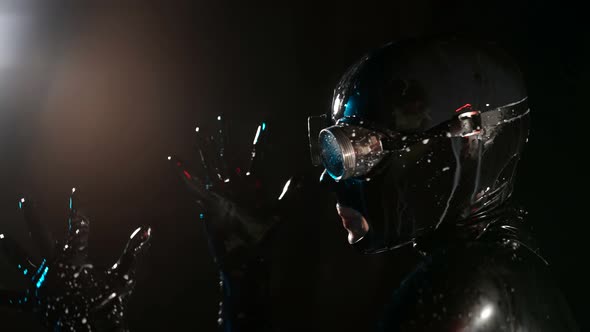 Closeup of a Head in a Black Latex Helmet Glasses and Drops of White Liquid