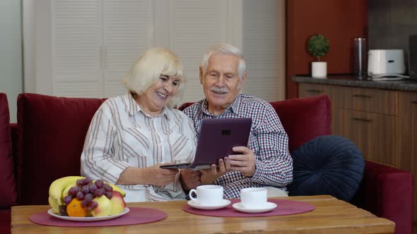 Senior Grandparents Couple Talking and Using Digital Laptop Computer at Home. Coronavirus Lockdown