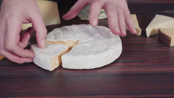 Time lapse. Large wedges of gourmet cheese on a rustic wood background.