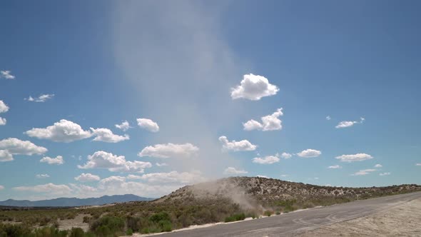 Dirt devil swirling across a road picking up dirt in the Utah desert