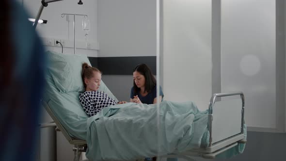 Worried Mother Standing with Daughter Praying While Sleeping After Recovery Surgery