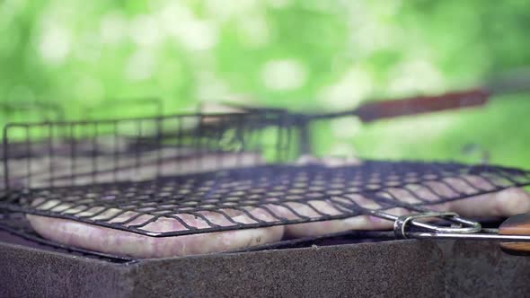 Cooking Meat Sausages on a Grill on Fire